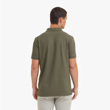 Back view of a man wearing a green polo shirt on a white background