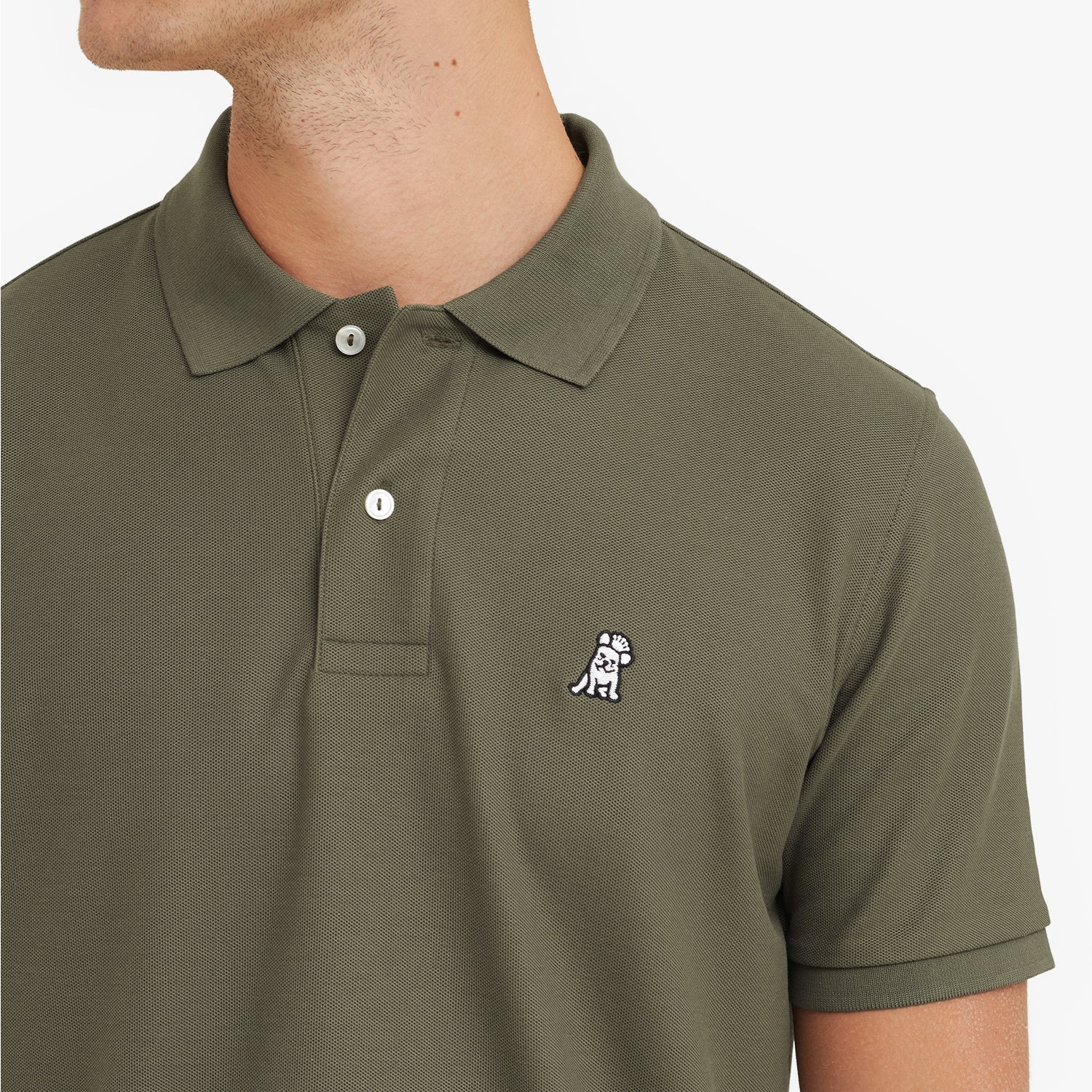 Close-up of a green polo shirt with a small logo on a plain background