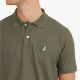 Close-up of a green polo shirt with a small logo on a plain background