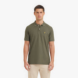 Man wearing a green polo shirt with a logo on a white background