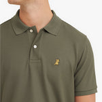 Close-up of a green polo shirt with a small logo on a white background