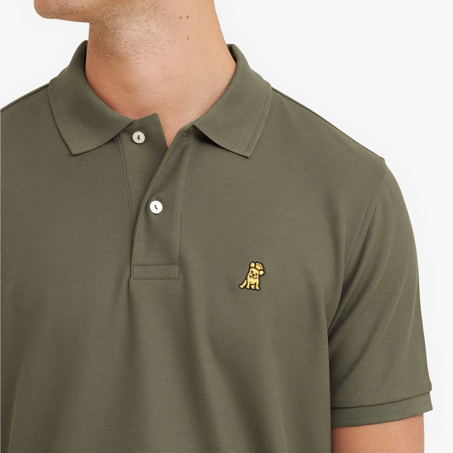 Close-up of a green polo shirt with a small logo on a white background