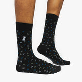 Black patterned socks worn by a person on a white background