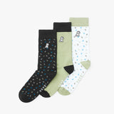 Three pairs of socks in black, green, and white with dog patterns on a white background