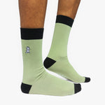 Light green socks with black accents worn by a person on a white background
