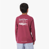Boy wearing a maroon rashguard with 'Saint Tropez' print on the back
