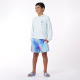 Child wearing a light blue rashguard and tie-dye shorts on a white background