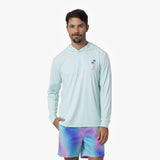 Man wearing a light blue rashguard and tie-dye shorts on a white background