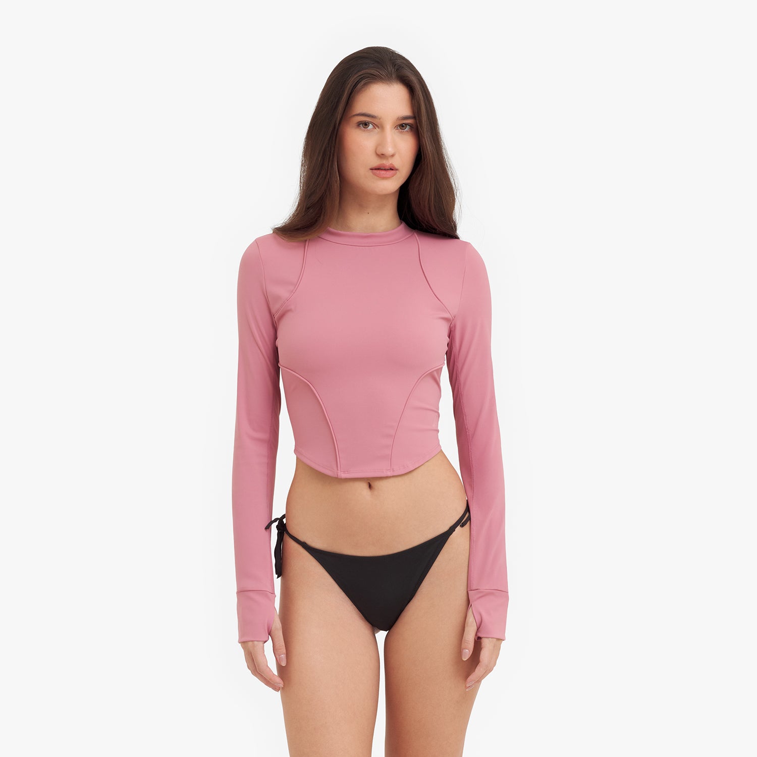 Woman wearing a pink long-sleeve rashguard and black bikini bottom