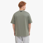 Back view of a man wearing a green t-shirt on a white background