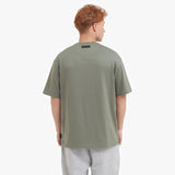 Back view of a man wearing a green t-shirt on a white background