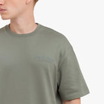Close-up of a green t-shirt with 'James Bark' logo on a white background