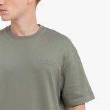 Close-up of a green t-shirt with 'James Bark' logo on a white background