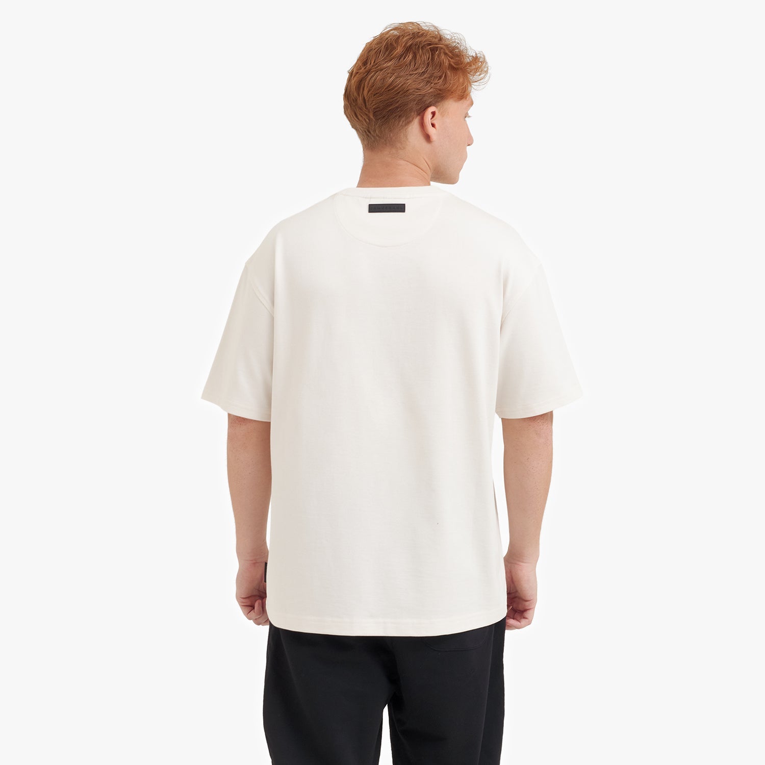 Back view of a man wearing a white t-shirt on a white background