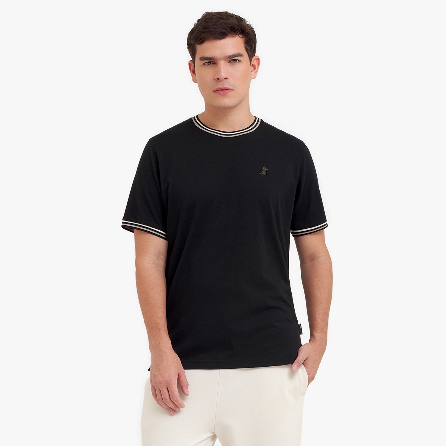 Man wearing a black t-shirt with white trim on a white background