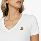 Close-up detail of the white v-neck t-shirt neckline, showing the fabric texture and the small gold embroidered dog logo on the left chest