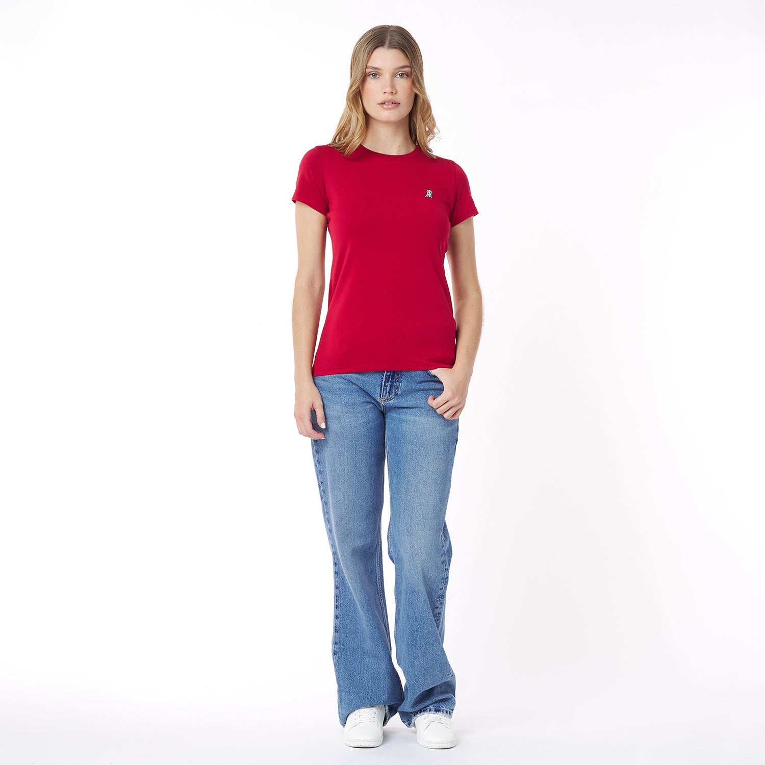 Woman wearing a red t-shirt and blue jeans on a white background
