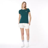 Woman wearing a green t-shirt and white shorts on a white background