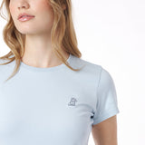 Close-up of a light blue t-shirt with a small logo on a white background
