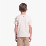 A child viewed from the back wearing a light cream/off-white short-sleeve t-shirt with a small black graphic on the upper back