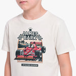 A child wearing a cream-colored t-shirt with a graphic print of a red James Bark Formula 1 car and checkered flags.