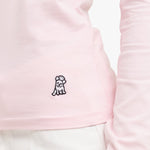 Close-up of a pink garment with a small black dog logo on a white background