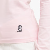 Close-up of a pink garment with a small black dog logo on a white background