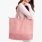 Pink tote bag with 'James Bark' branding held by a person
