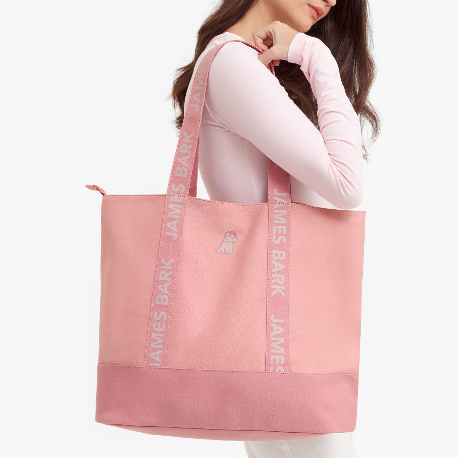 Pink tote bag with 'James Bark' branding held by a person