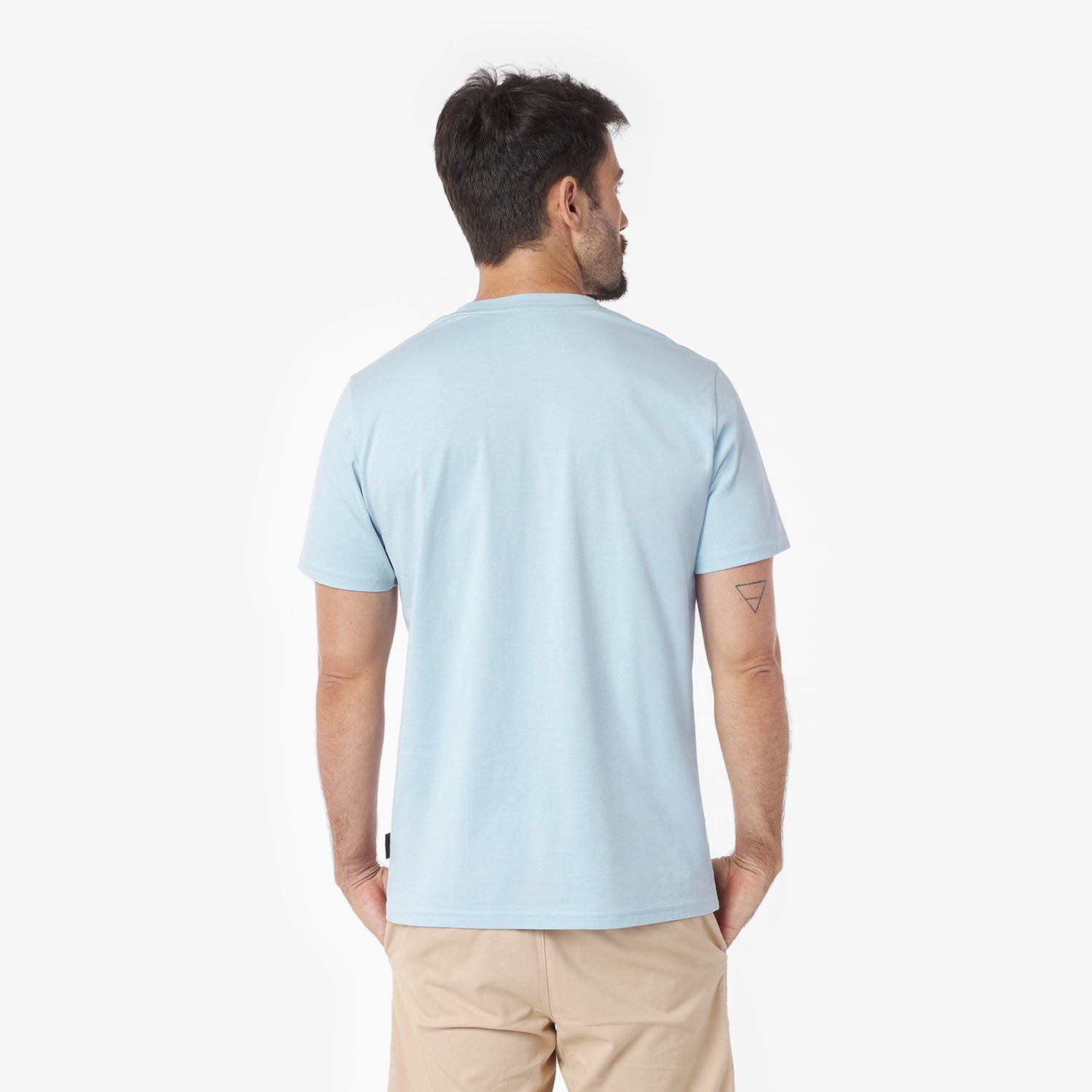 Back view of a man wearing a light blue t-shirt on a white background
