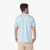 Back view of a man wearing a light blue t-shirt on a white background
