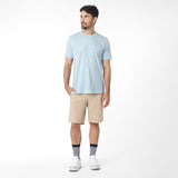 Man wearing a light blue t-shirt and beige shorts on a white background