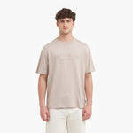 Man wearing a beige t-shirt with text on a white background