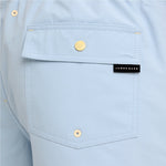 Close-up of a light blue shirt pocket with gold-tone snap buttons and a black James Bark brand label.