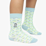 Light blue and green patterned socks worn by a person on a white background
