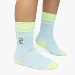 Light blue socks with green accents worn by a person on a white background