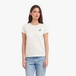 Woman wearing a white t-shirt with a small green logo on a white background