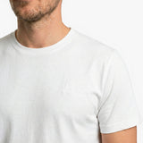 Close-up of a white t-shirt worn by a person on a white background