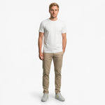 Man wearing a white t-shirt and beige pants on a white background