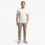 Man wearing a white t-shirt and beige pants on a white background