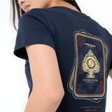 A close-up of a model wearing a navy blue t-shirt, showing the back graphic. The graphic is styled like a playing card deck with gold and red details, featuring the text 'JAMES BARK EST.