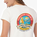 A woman shown from the back wearing a white T-shirt with a large, colorful circular graphic on the back. The graphic includes the text 'COASTAL LEGACY', 'JAMES BARK', 'MONTE CARLO', and 'SAILING CLUB' around a sailboat scene.