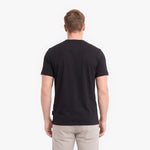 A man viewed from behind wearing a plain black short-sleeve crewneck t-shirt