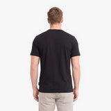 A man viewed from behind wearing a plain black short-sleeve crewneck t-shirt