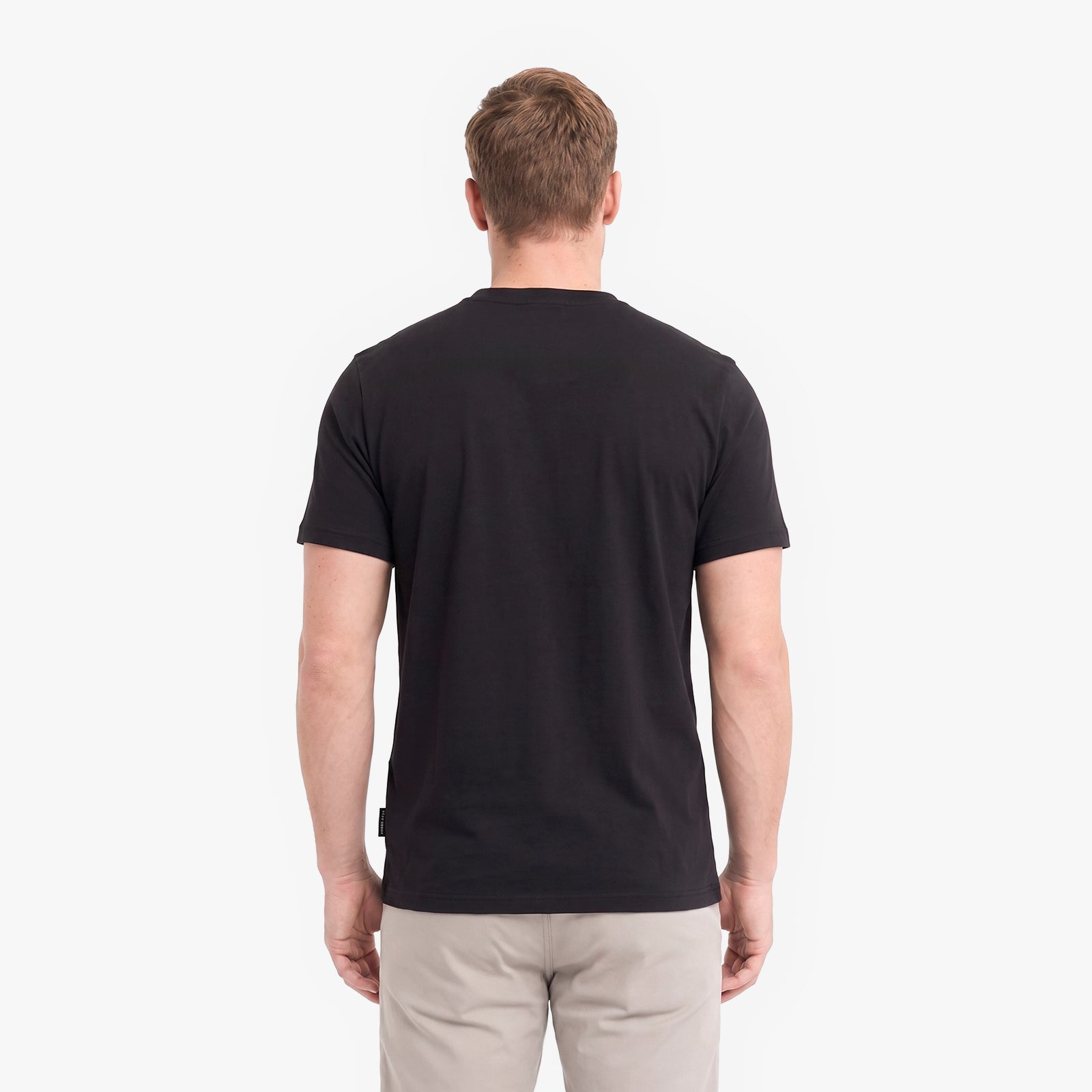 A man viewed from behind wearing a plain black short-sleeve crewneck t-shirt