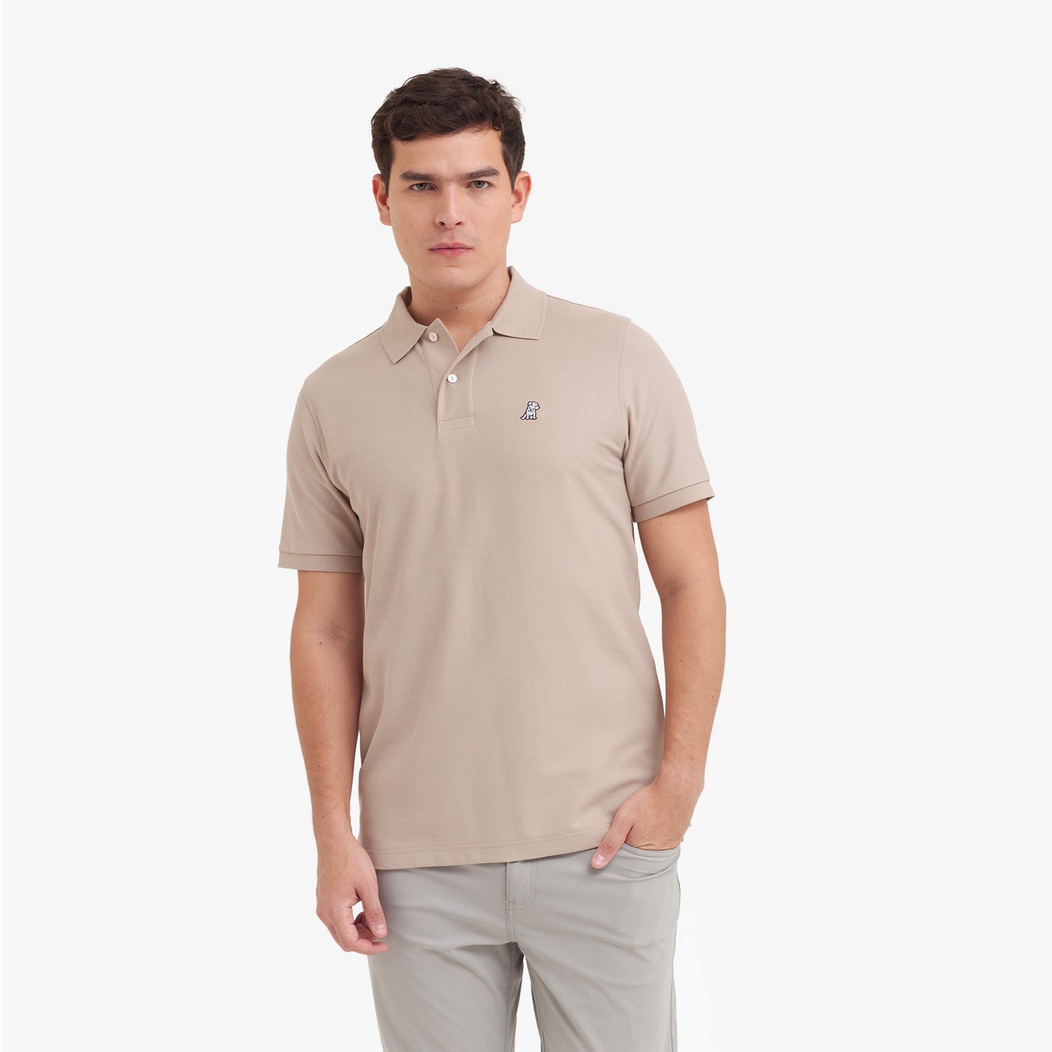 Man wearing a beige polo shirt with a small logo on a white background