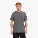 Man wearing a gray t-shirt with a small logo on a white background