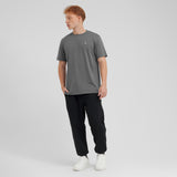 Person wearing a gray t-shirt and black pants on a white background