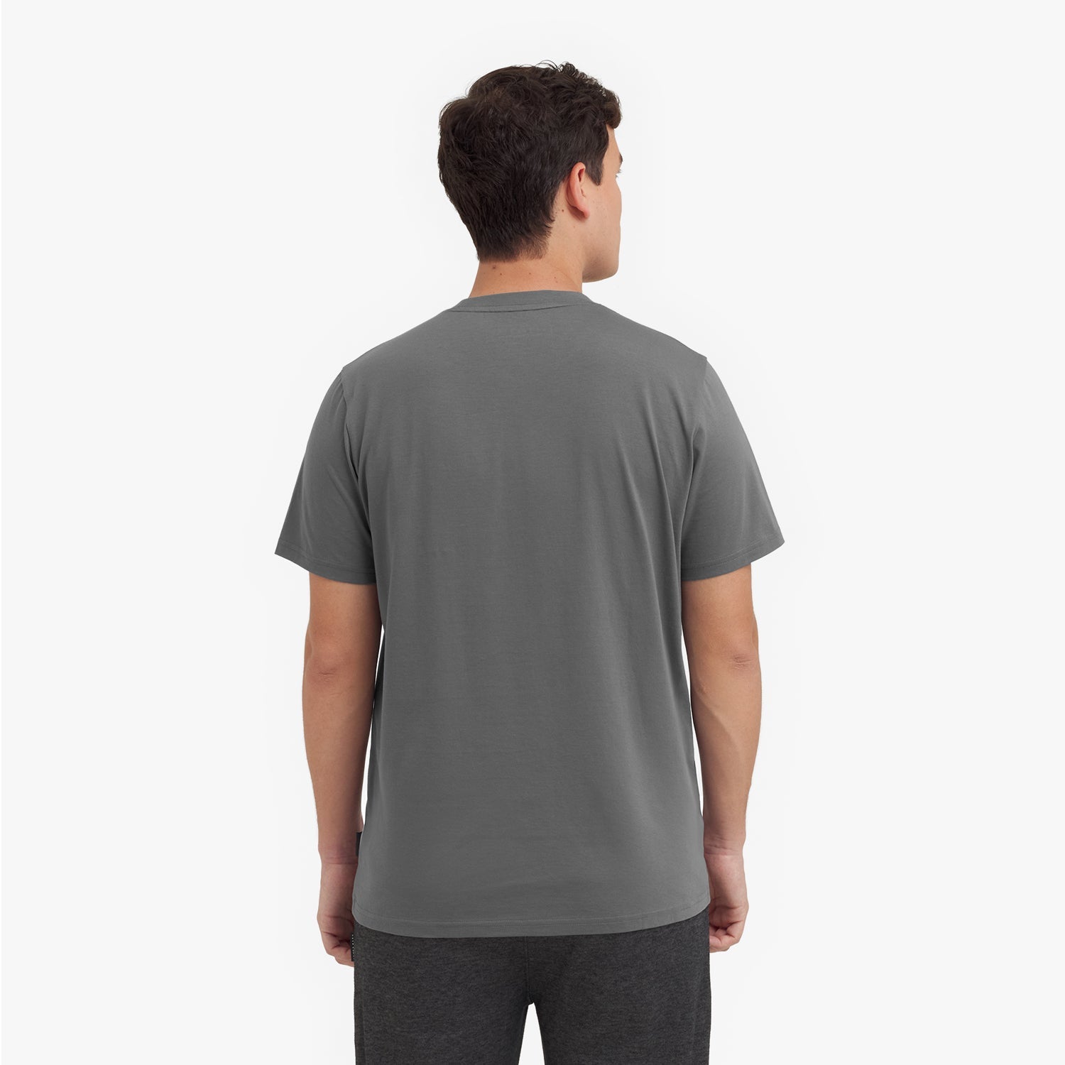 Back view of a man wearing a gray t-shirt on a white background