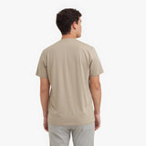 Back view of a man wearing a beige t-shirt on a white background